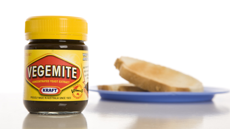 Jar of Vegemite with blue plate filled with toast