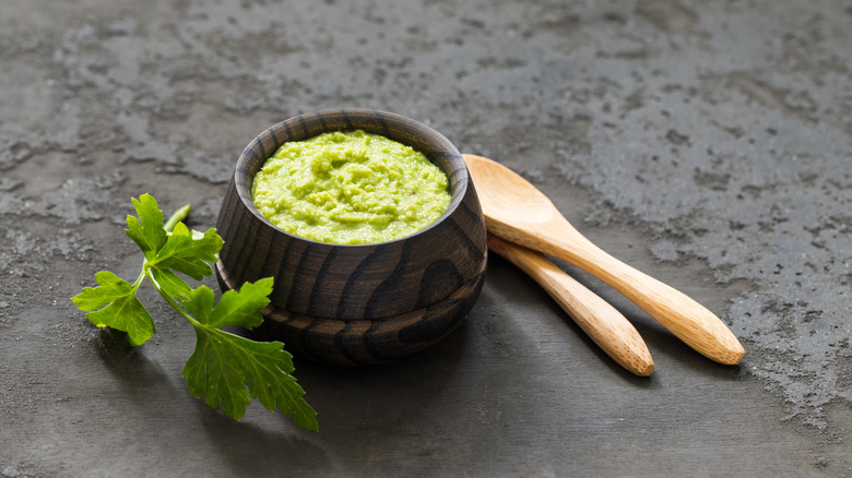 Wasabi paste in small wooden bowl with wooden spoons