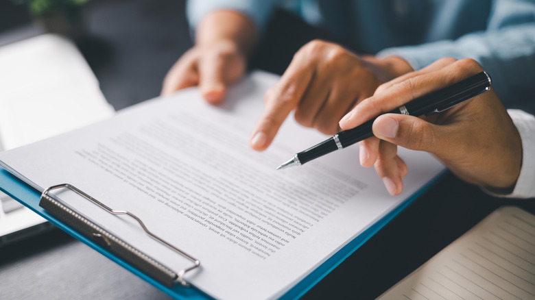 A hand holding a pen over a printed document.