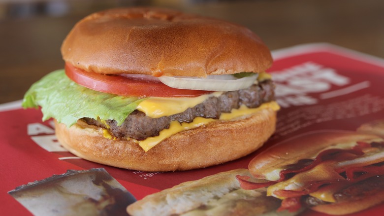 a Wendy's Dave's Single cheeseburger on a tray with Wendy's advertisements.