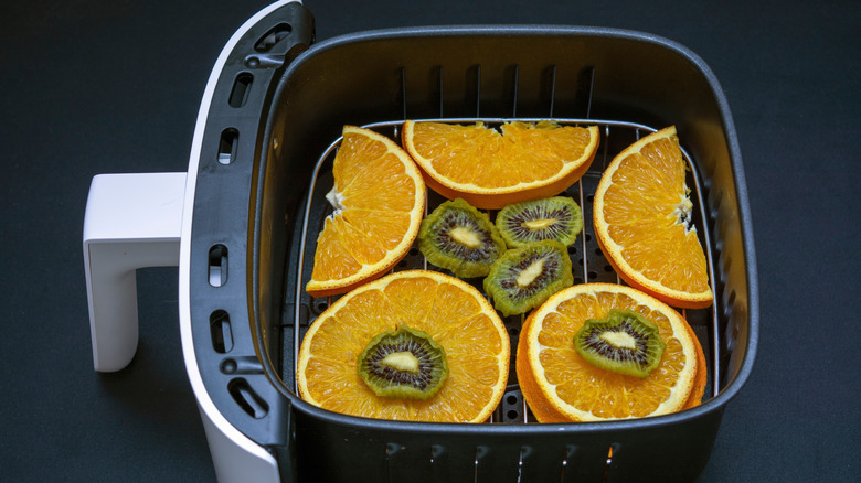 Sliced oranges and kiwi in an air fryer