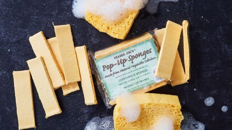 A package of Pop-up sponges surrounded by sponges, both dry and flattened, and rehydrated.