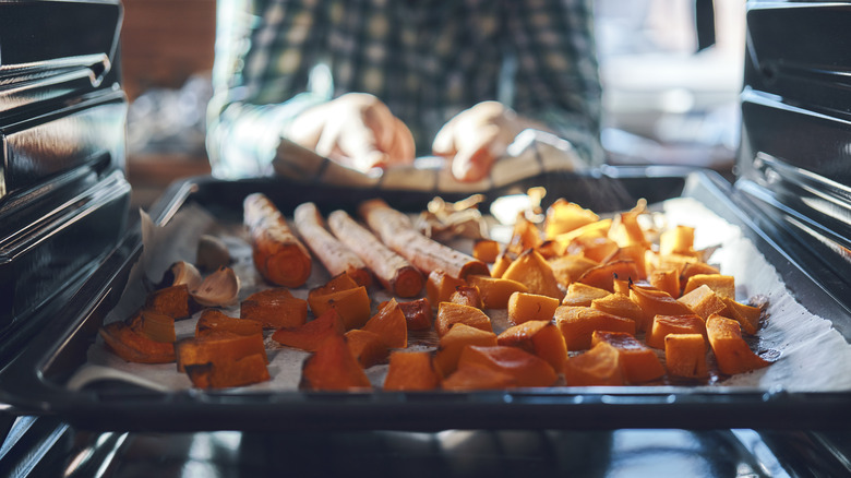 Cook putting tray into oven