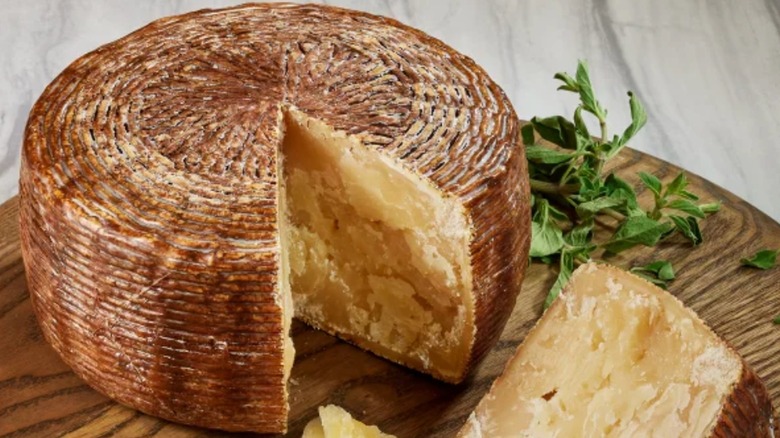 Wheel of pecorino calabrese cheese with a wedge cut out of it