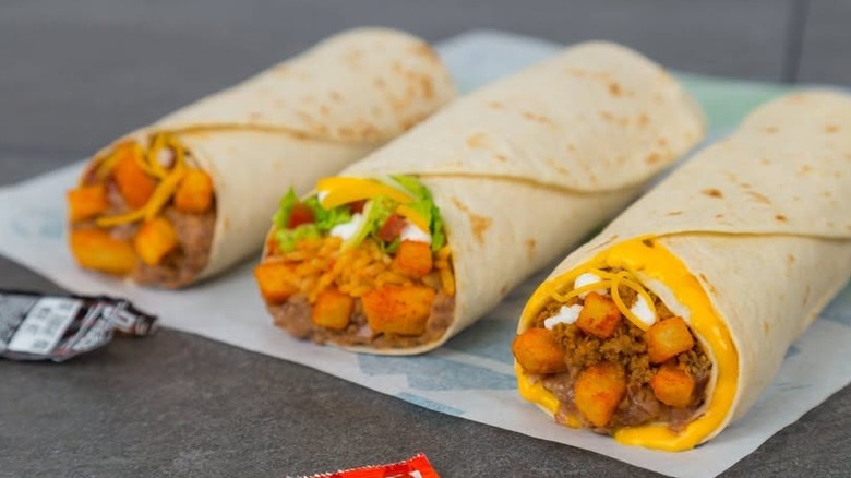 Three burritos with Taco Bell nacho cheese fries inside
