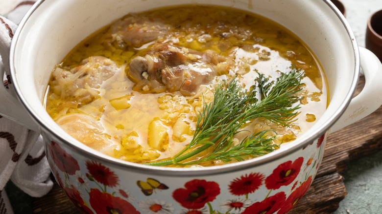 Pot of chicken stew, with a sprig of herbs
