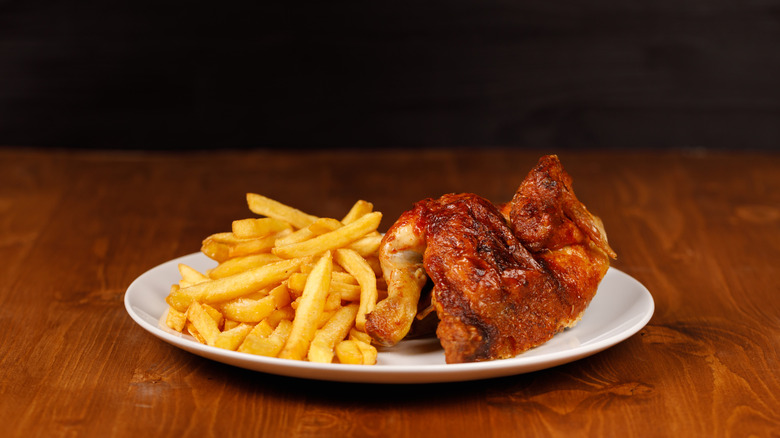 Plate of a half roasted chicken and fries
