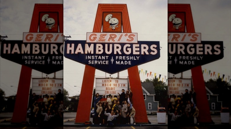 Image of a Geri's Hamburger sign, with college students standing underneath it