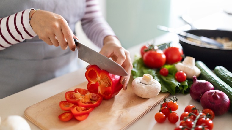 Person using a knife to cut a bell pepper