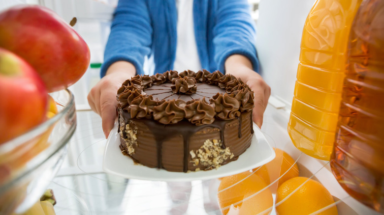 taking chocolate cake from fridge