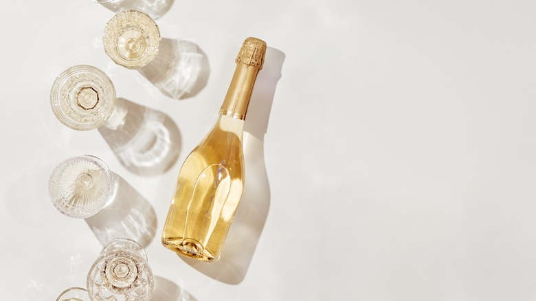 White wine bottle and glasses against a white surface