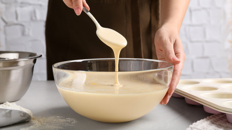Spooning cake batter in mixing bowl