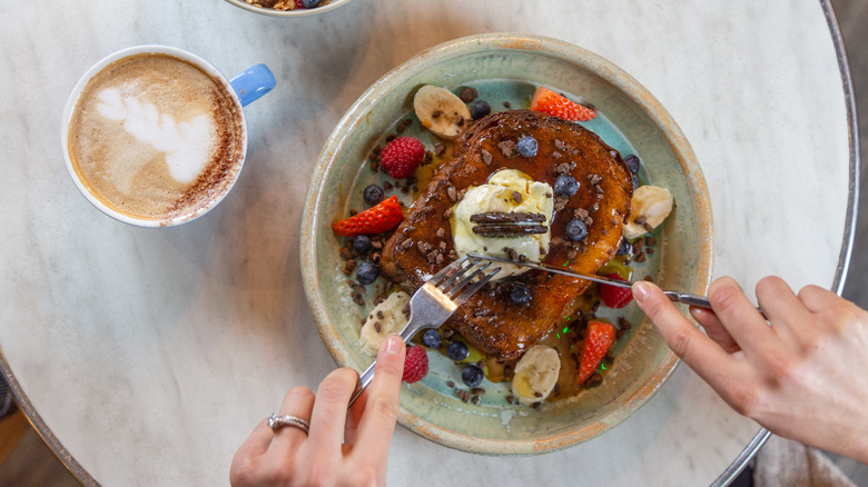 French toast served with syrup, fruit, and cream