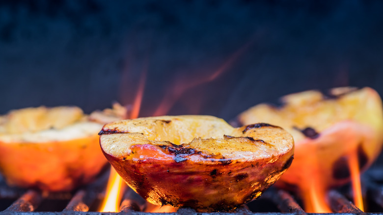 peaches on the grill with a flame