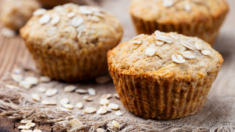 Close-up of oat muffins on cloth mat atop wooden table