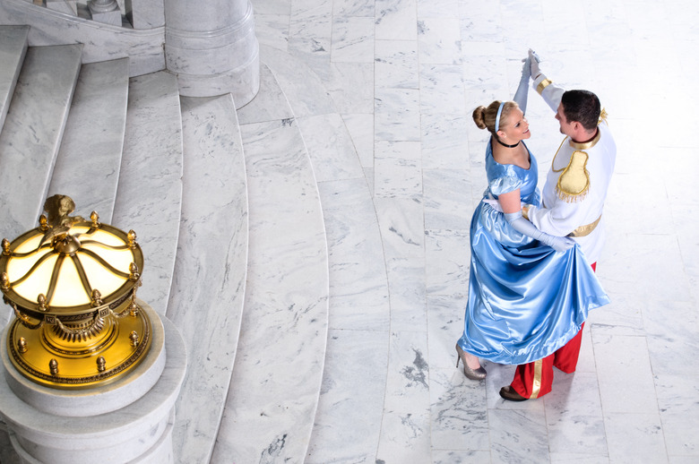 Adults dressed as Cinderella and Prince Charming dancing
