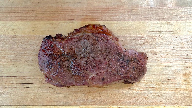 Cooked Black Angus Choice Beef Strip Steak on a wood countertop