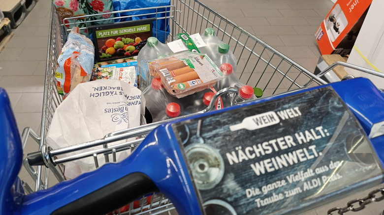 An Aldi shopping cart is filled with food and drinks.