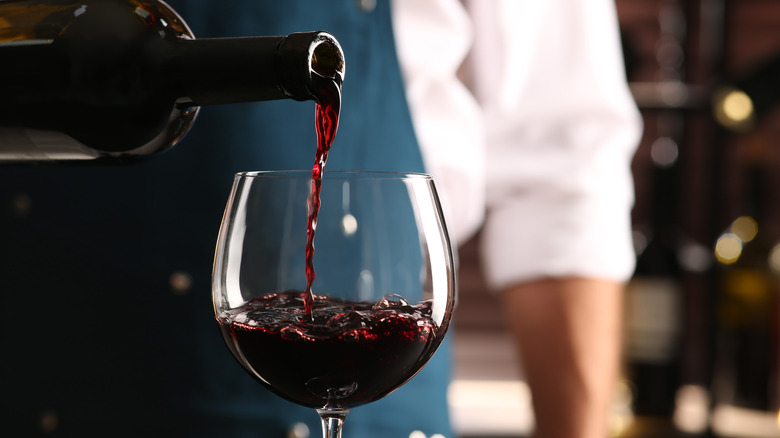 Waiter pouring wine