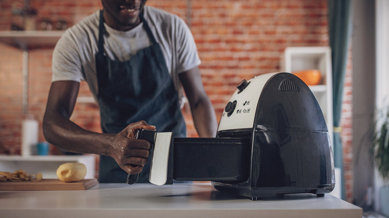 African-American man cooking with air fryer
