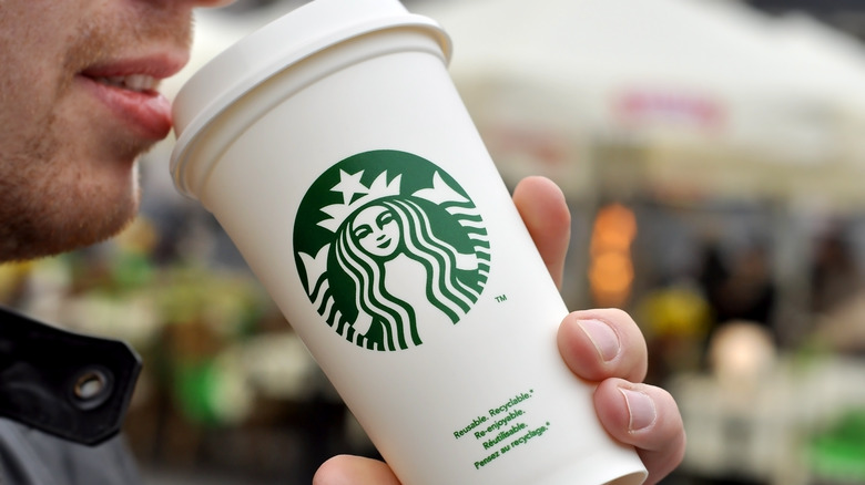 Person sipping Starbucks drink