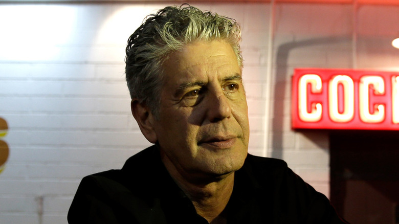 Anthony Bourdain talks to reporters outside of a bar
