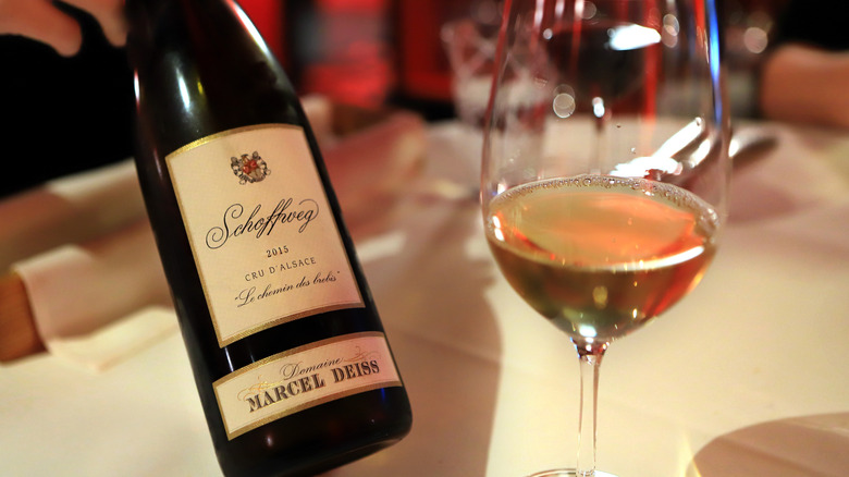 Glass of white wine next to bottle