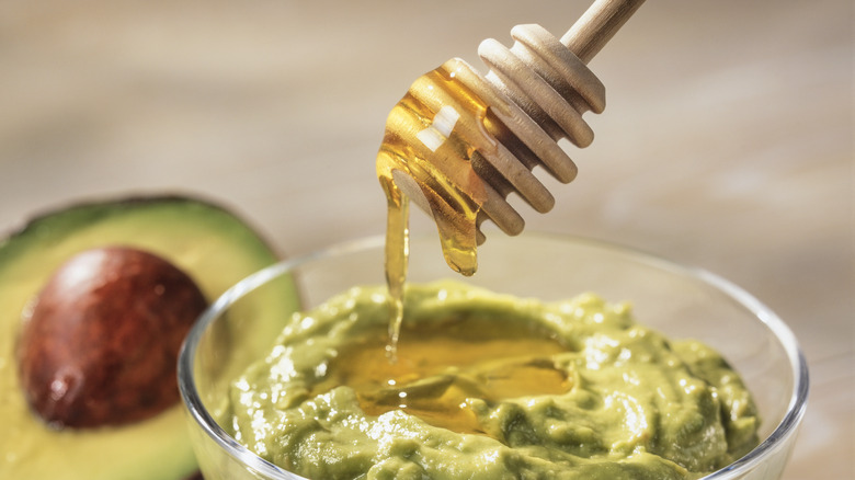 Drizzling honey into avocado mash