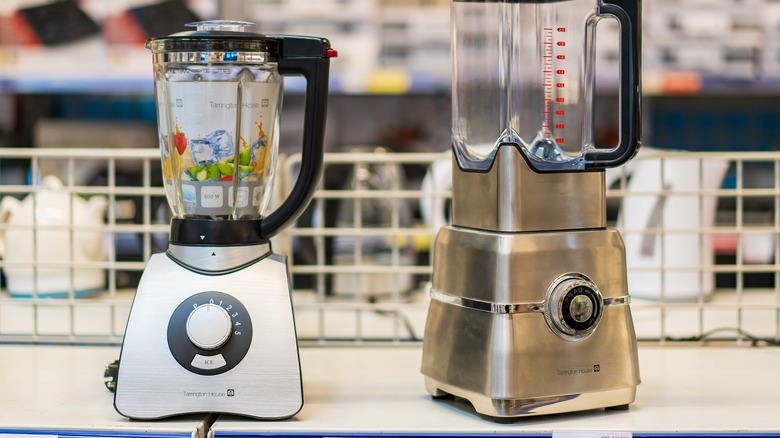 Two blenders on a white store shelf.