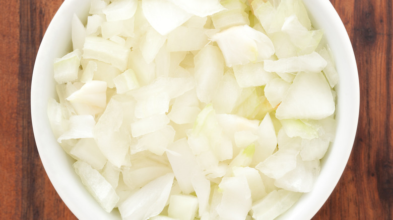 Bowl of diced onions on wood