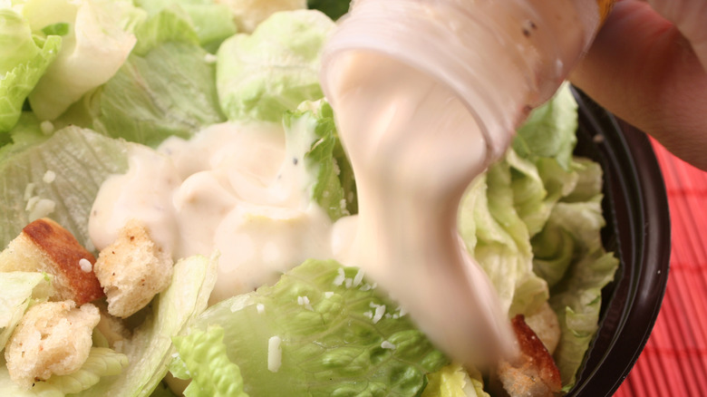 Pouring dressing on salad