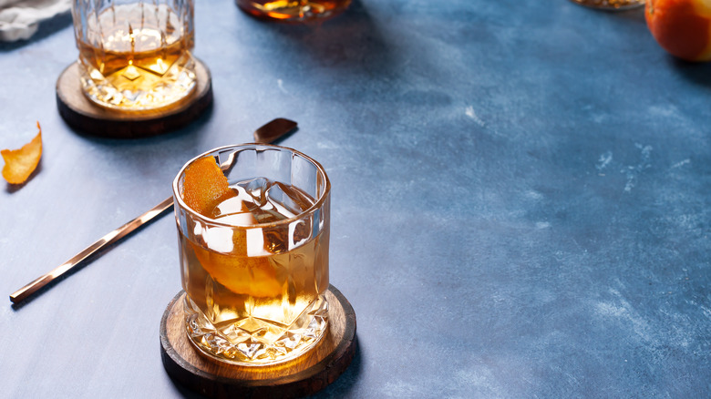 Bourbon cocktail in glass, with orange slice and cocktail stirrer