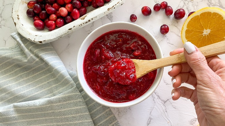 cranberry sauce in white bowl with spoon