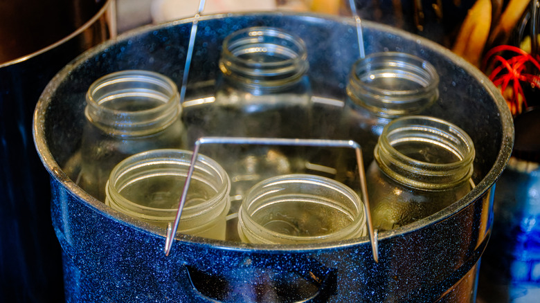 Six empty mason jars inside deep pot