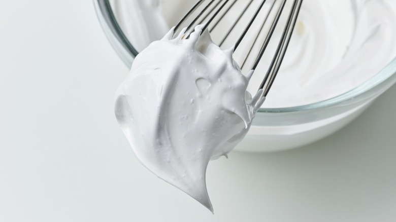 whisk with fluffy whipped cream 