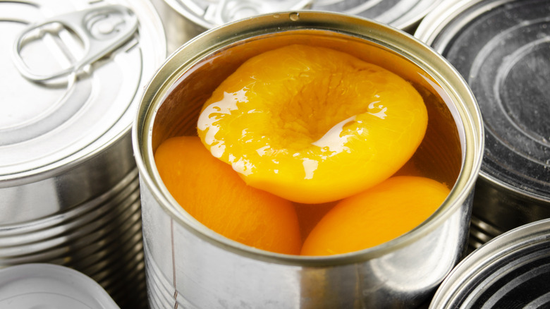 Open tin of canned peach halves