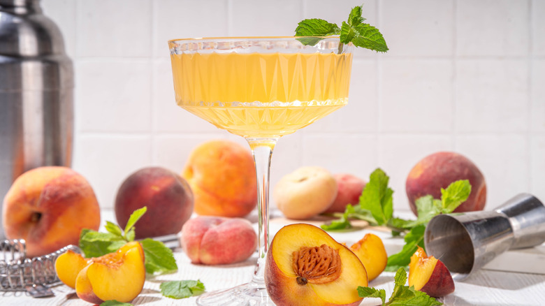 Peach martini by freshly sliced peaches and jigger