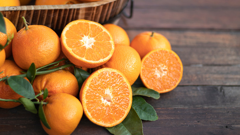 Oranges with leaves on a wooden table