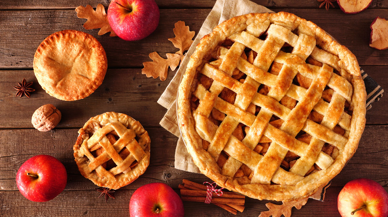 Lattice-crust apple pies on wooden table