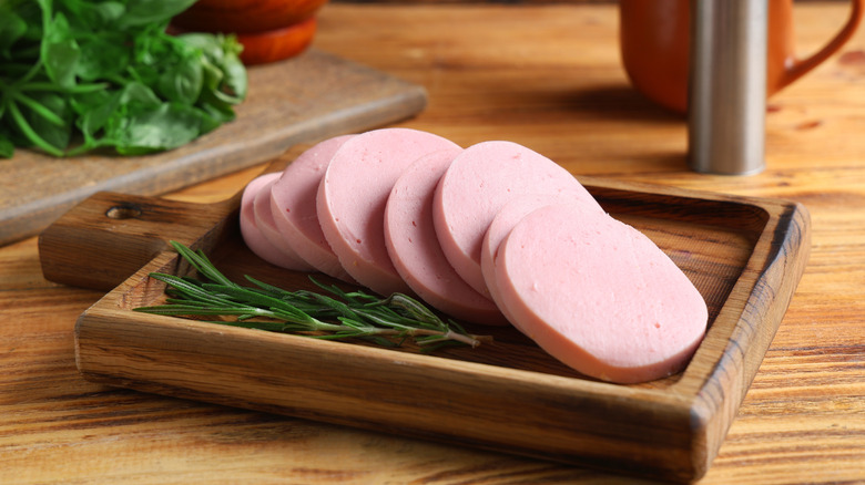 slices of thick-cut bologna on a wood cutting board