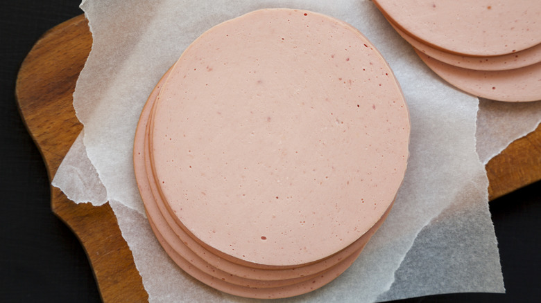 Sliced pork bolgna meat on rustic wooden board