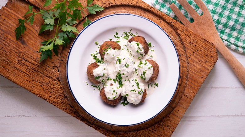 Seven meatballs served with a yogurt sauce