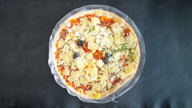 Frozen veggie pizza on gray background
