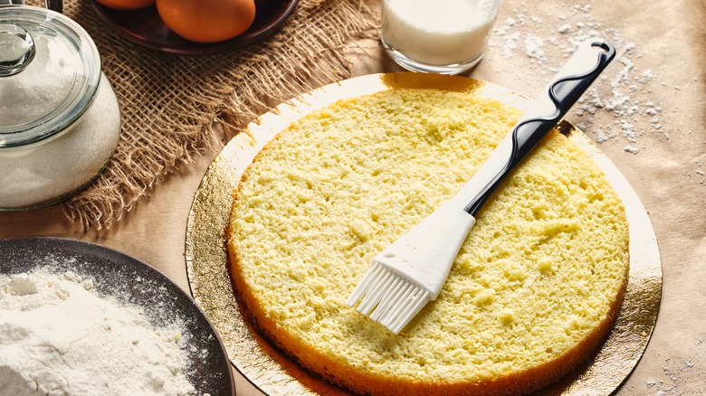Brushing cake with milk