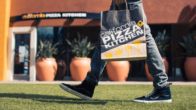 Person holding California Pizza Kitchen bag