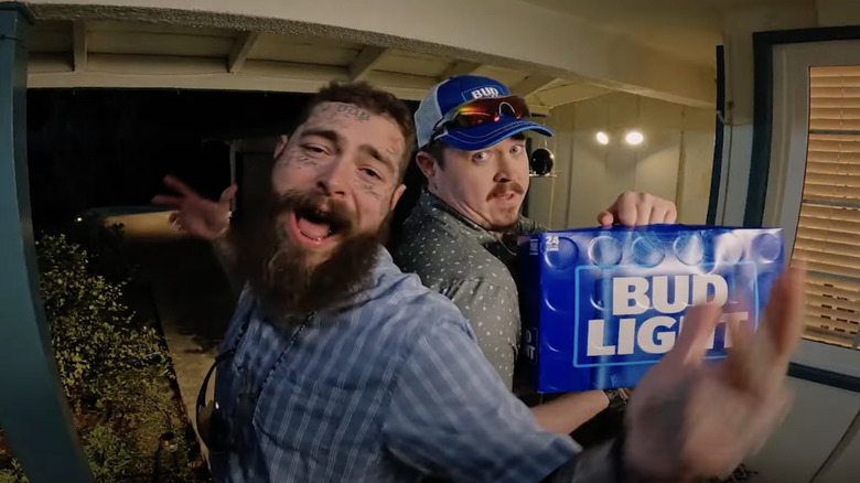 Post Malone and Shane Gillis holding up a Bud Light 24 pack