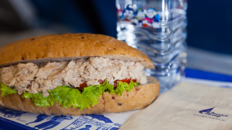 Tuna sandwich on airplane napkin laid out on tray table