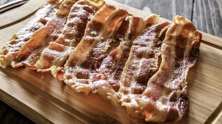 Cooked bacon on wooden platter