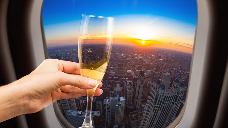 Holding champagne glass in airplane