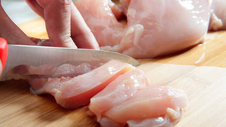cutting up chicken in chunks